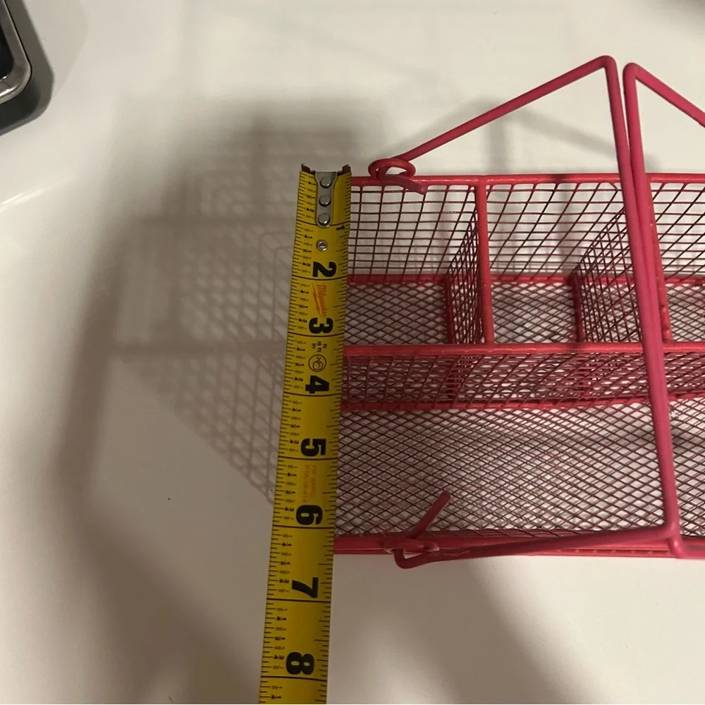 Small pink metal wire organizer with compartments and handles for utensils